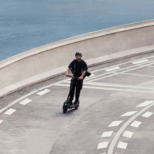 Segway Ninebot Max G3 electric scooter riding on curved road.